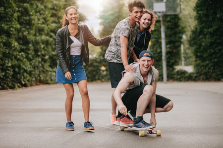 Teenage guys on skateboard with girls