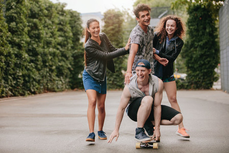 Four teenagers enjoying outdoors with skateboard