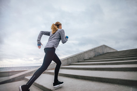 Fit young woman running on steps