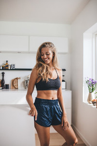 Beautiful young woman standing in kitchen and smiling