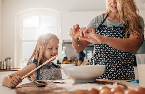 Mother and daughter preparing food in kitchen
