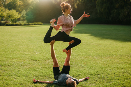 Man and woman doing various yoga poses in pair