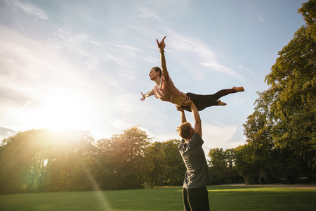 Couple practicing acroyoga at park