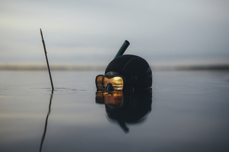 Spearfishing diver with reflection of sunset in diving mask