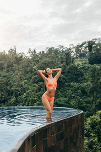 Attractive young woman in bikini posing in the pool