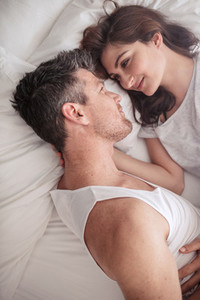 Intimate young couple lying in bed