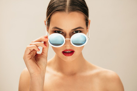 Fashion woman peeking over sunglasses