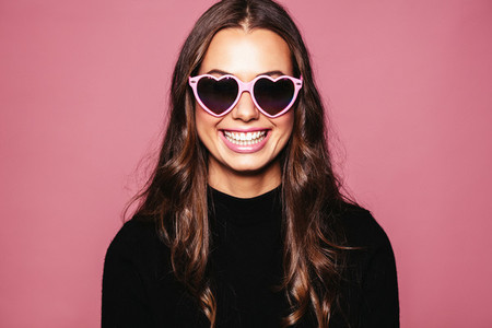 Beautiful young woman with heart shaped sunglasses