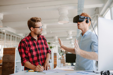 Young men testing virtual reality headset