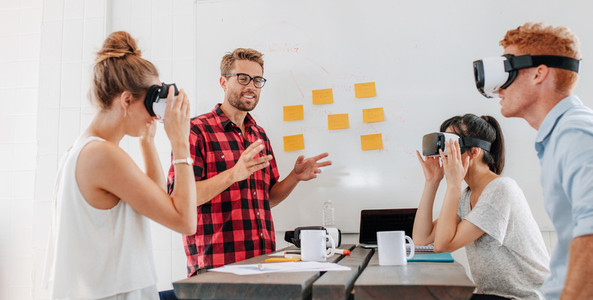 Business people using virtual reality goggles during meeting