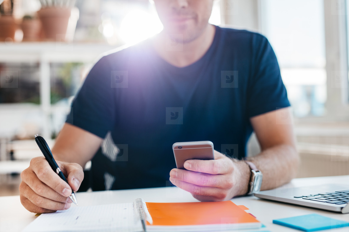 Businessman using mobile phone while working in office