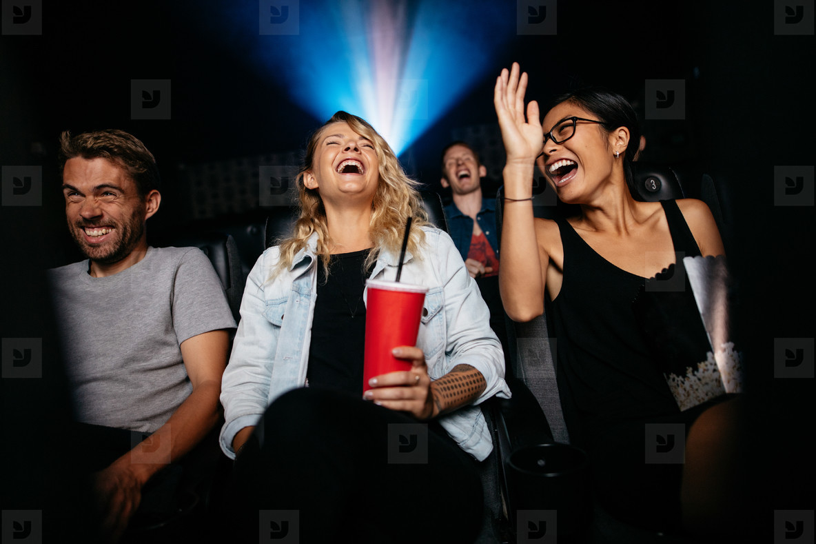 Young friends watching comedy movie on theater stock photo (125778) -  YouWorkForThem