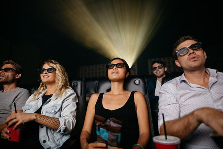 Young people watching 3d movie in theater