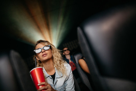 Beautiful woman watching 3d movie in theater