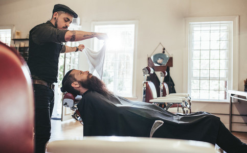 Barber taking care of client in barbershop