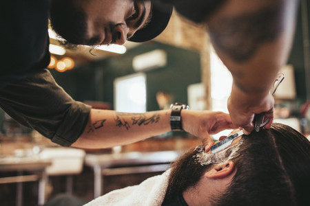 Barber shaving bearded man