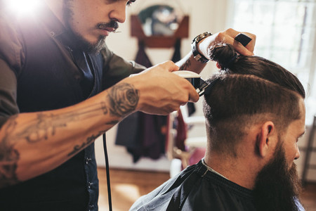 Man getting trendy haircut in barber shop