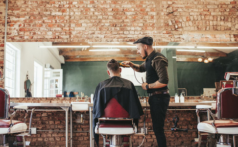 Hairstylist cutting hair of male customer