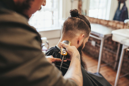 Man getting haircut by barber at salon
