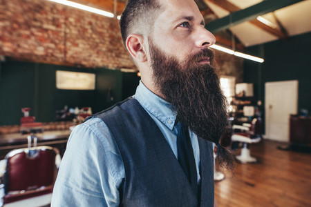 Serious male barber with long beard