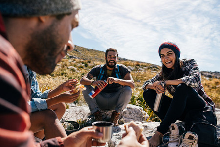 Group of people relaxing and eating during hike