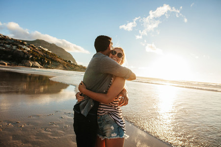 Romantic young couple embracing on beach