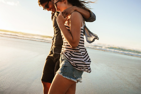 Couple strolling together on beach on a summer day