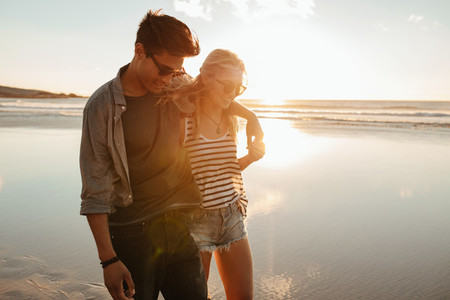 Romantic young couple on beach during sunset