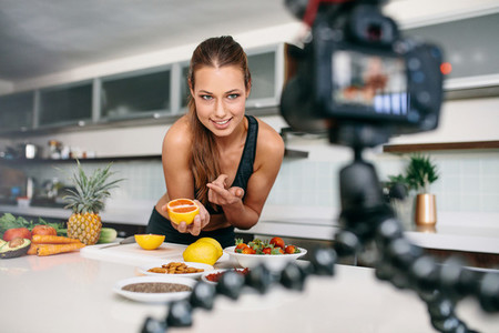 Young female blogger recording content for videoblog in Kitchen