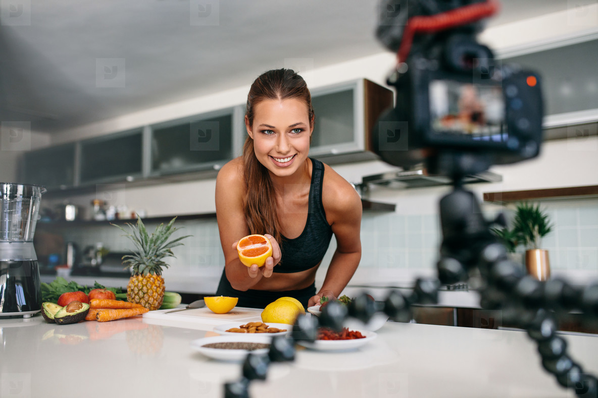 Young female blogger recording content for videoblog in Kitchen.