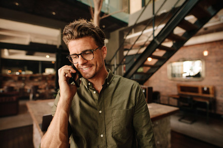 Smiling executive talking on mobile phone in office