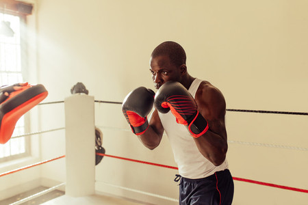 Focused young male boxer practicing