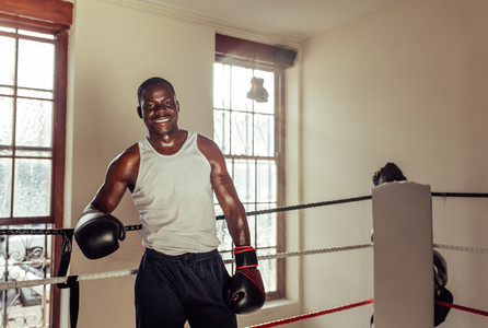 Happy sweaty fit young African boxer