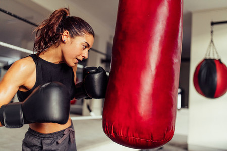 Determined young female boxer working out