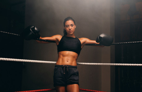 Muscular female athlete wearing boxing gloves