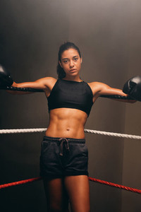 Young female boxer wears gloves and black shorts