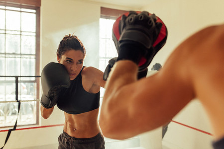 Muscular female pugilist throws a punch