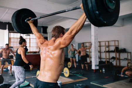 Muscular bodybuilder lifting weights in gym