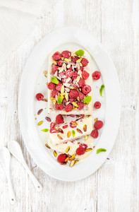 Homemade semifreddo with pistachio and raspberry in white oval dish
