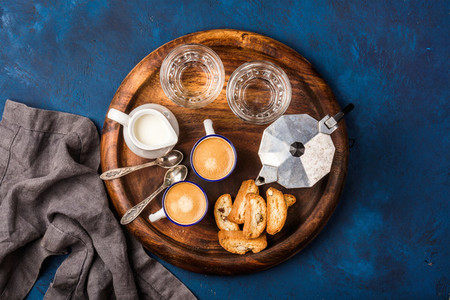 Coffee espresso cantucci cookies milk and water on wooden board