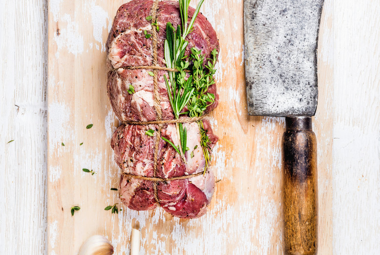Raw roastbeef meat cut with herbs over white wooden background