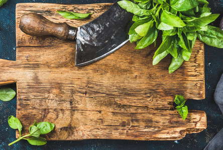 Fresh basil and vintage herb chopper on rustic wooden bord