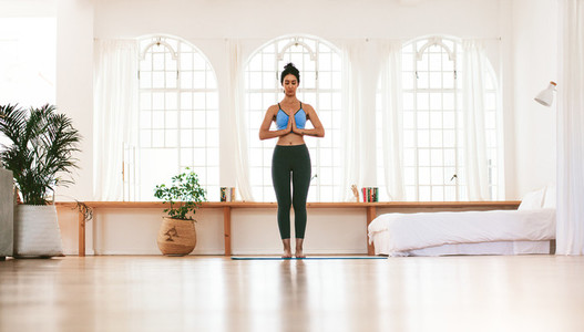 Fit young woman meditating indoors