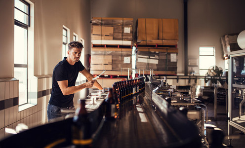 Brewer supervising the process of beer manufacturing