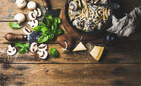 Creamy mushroom pasta spaghetti in cast iron pan with basil