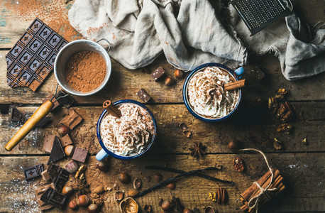 Hot chocolate with whipped cream  nuts and cinnamon in mugs