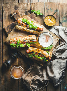 Wheat unfiltered beer and grilled sausage dogs in baguette