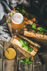 Glass and bottle of unfiltered beer grilled sausage dogs