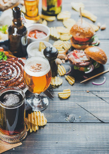 Octoberfest beer and snacks set on dark scorched wooden background