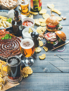 Beer and snack variety on dark wooden scorched background